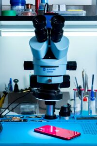 A microscope and smartphone on a lab bench, highlighting tech integration in research.